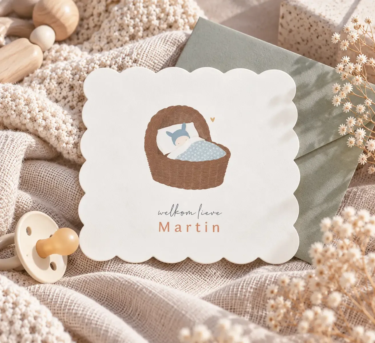 Minimalistisch geboortekaartje met baby in wiegje en sage envelop